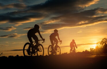 backside-cyclists-ride-bicycle-sunset-time-background